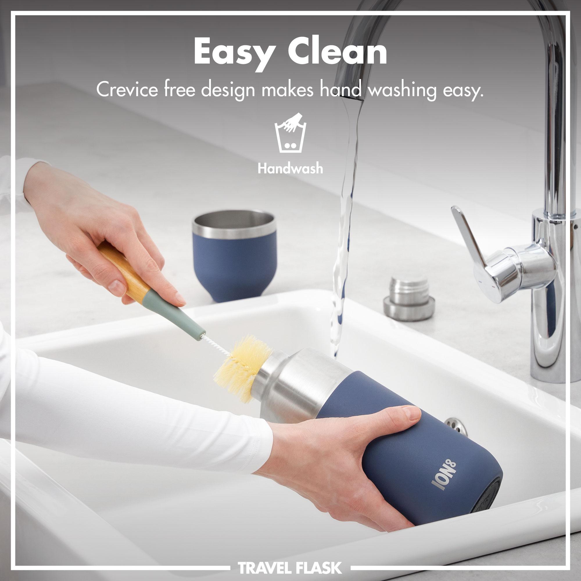 Person cleaning an ION8 travel flask with a brush in a sink, with text indicating easy cleaning and crevice-free design.