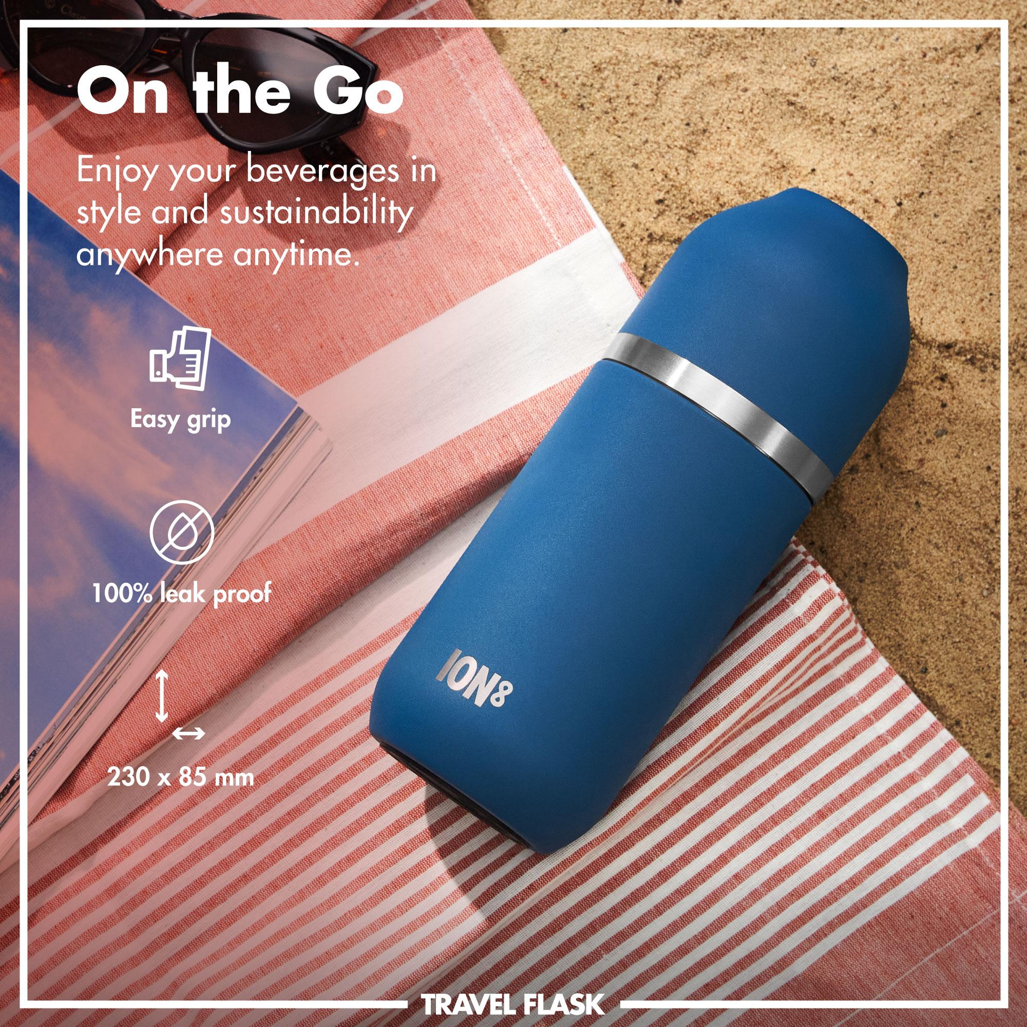 Blue ION8 travel flask with silver band on a beach towel, promotional text about its features.