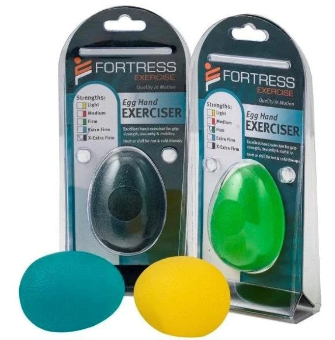 Two packaged Fortress Exercise egg hand exercisers on a white background, with one dark gray/black egg in the left package and one green egg in the right package. Two loose eggs, one teal and one yellow, are placed in front.